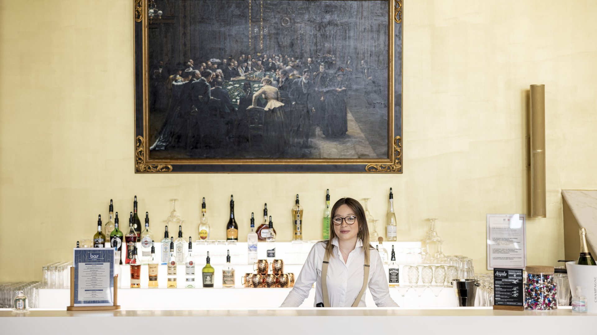 Professionnel préparant des cocktails raffinés dans l'ambiance animée du casino.