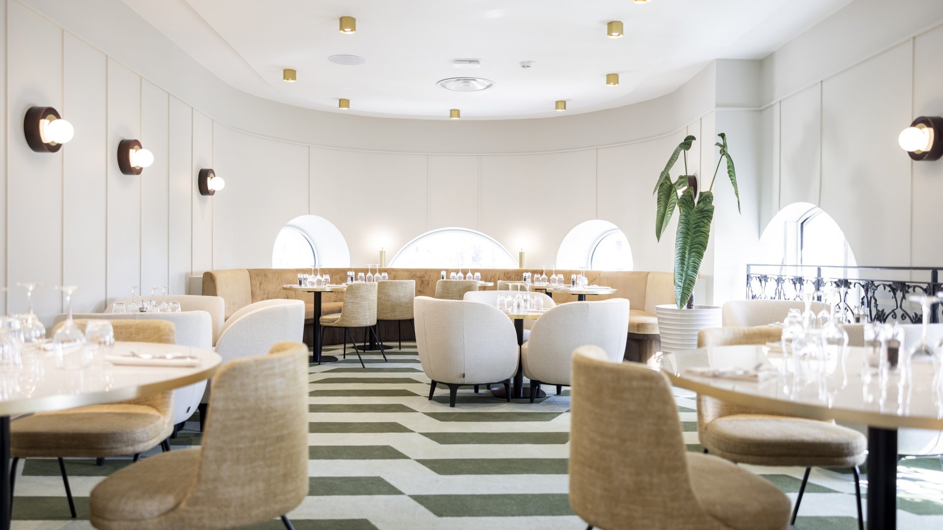 Intérieur du restaurant du casino, décoré avec des tons blancs et une lumière chaleureuse, offrant une atmosphère raffinée